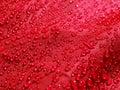 Red waterproof fabric with waterdrops close up Royalty Free Stock Photo