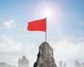 Red wavy flag on top of rocky mountain peak Royalty Free Stock Photo