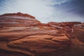 Red wavy sandstone formation of Glan Canyon National Recriation area, Arizona, dramatic cloudy sky background Royalty Free Stock Photo