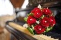Red wedding flowers on the piano