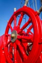 Red wheel helm on antique ship