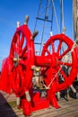 Red wheel helm on antique ship