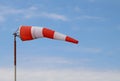 Red and white airport windsock blowing at about 45 degrees Royalty Free Stock Photo