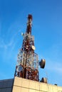 Red and white antenna (cellular tower) under blue sky. Royalty Free Stock Photo