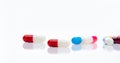 Red-white antibiotic capsule pill on blur multi-colored capsules background. Antibiotic drug resistance concept. Pharmacy Royalty Free Stock Photo