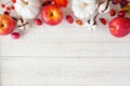 Red and white autumn top border with apples & pumpkins on white wood Royalty Free Stock Photo