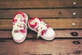 Red and white baby shoes on wooden chair Royalty Free Stock Photo