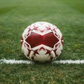 red and white ball on the green turf of the football field Royalty Free Stock Photo