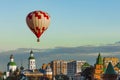 Red and white balloon flies very low over the city, directly over the Christian Church and the Kremlin in the clear cloudless sky Royalty Free Stock Photo