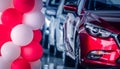 Red and white balloons decorated in modern car showroom on blurred of front view red SUV car. New and shiny luxury SUV car parked