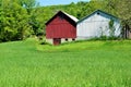 Red and white barns on green mountainside Royalty Free Stock Photo