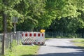 Red white barricade with warning lights as a safety measure for earthworks during cable and fiber optics laying on a country road