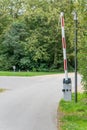 A red and white barrier stands at the edge of a paved path. Royalty Free Stock Photo