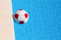 Red-white beach ball floating in swimming pool Royalty Free Stock Photo