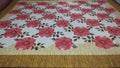 Red and white bedsheet with floral print on it