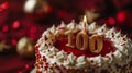 A red and white birthday cake with a '100' candle. Royalty Free Stock Photo