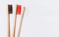 Red, white and black bamboo toothbrushes on white background. Copy space Royalty Free Stock Photo