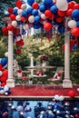 red, white, and blue balloons floating above a festive outdoor setup