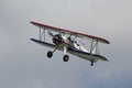 Red, White, and Blue Biplane Flying in the Sky Royalty Free Stock Photo