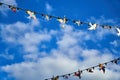 Red white and blue triangular bunting on sky background. Garland of flags stretched against a blue sky with white clouds Royalty Free Stock Photo