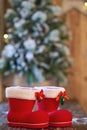 Red with white border Christmas boot near Christmas tree on wooden background Royalty Free Stock Photo