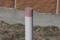 red white boundary post made of iron pipe outside
