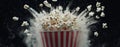 A red and white bucket of popcorn, floating with motion particles, on a dark black background, perfect for visual Royalty Free Stock Photo