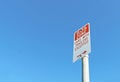 Red and white Bus Zone sign in a blue sky