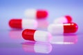 Red and white capsules (bolus) on violet Royalty Free Stock Photo