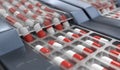 Red and white capsules in pharmaceutical production line. 3D rendered illustration.
