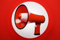 Red and white cartoon loudspeaker on a red monochrome background. Royalty Free Stock Photo