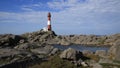 Red and white cast iron Eigeroy Lighthouse and anorthosite rock formations Royalty Free Stock Photo