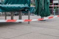 Red and white caution tape restrict outdoor eating area of cafe and restaurant which closed during epidemic of COVID-19 Royalty Free Stock Photo