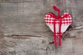 Red/white checkered heart shape hanging on a wooden background f Royalty Free Stock Photo