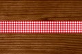 Red and white checkered tablecloth stripe on wooden table