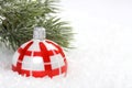 Red and white christmas balls on snow and icing pine branch