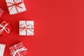 Red and white christmas gifts on a red background. Flat lay with blank copy space