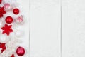 Red and white Christmas ornament side border over white wood Royalty Free Stock Photo