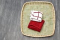 Red and white cloth napkins folded to cover bread or tortillas lying in a basket on a vintage gray wooden table Royalty Free Stock Photo