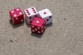 Set of red and white dice with hearts thrown on the sand at the beach Royalty Free Stock Photo