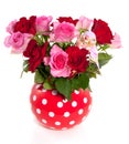 A red white dotted vase with a bouquet of roses