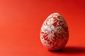 red and white easter decorative egg and paper on red background
