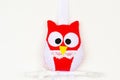 Red and white felt owl on wood branch. Composition for Valentine`s day