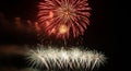 Red and white fireworks exploding in a dark night sky with smoke explosion display Royalty Free Stock Photo