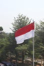 The red and white flag flies atop the flagpole Royalty Free Stock Photo