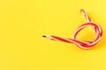Red and white flexible pencil. Isolated on yellow background