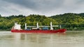 Red and white freighter container ship traveling along the Seine River from Paris to the English Channel Royalty Free Stock Photo