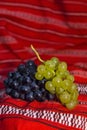 Red and white grapes on a traditional Romanian carpet Royalty Free Stock Photo