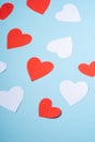 Red and white handmade paper hearts valentines on blue background