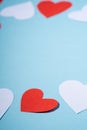 Red and white handmade paper hearts valentines on blue background